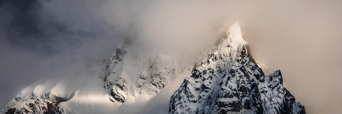 Panoramique des aiguilles de Chamonix fraichement enneigé et partiellement masqué par les nuages